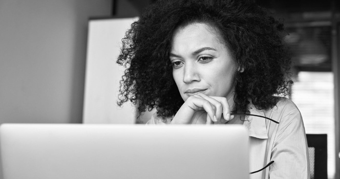 A woman reading an article about cyber attacks on her laptop